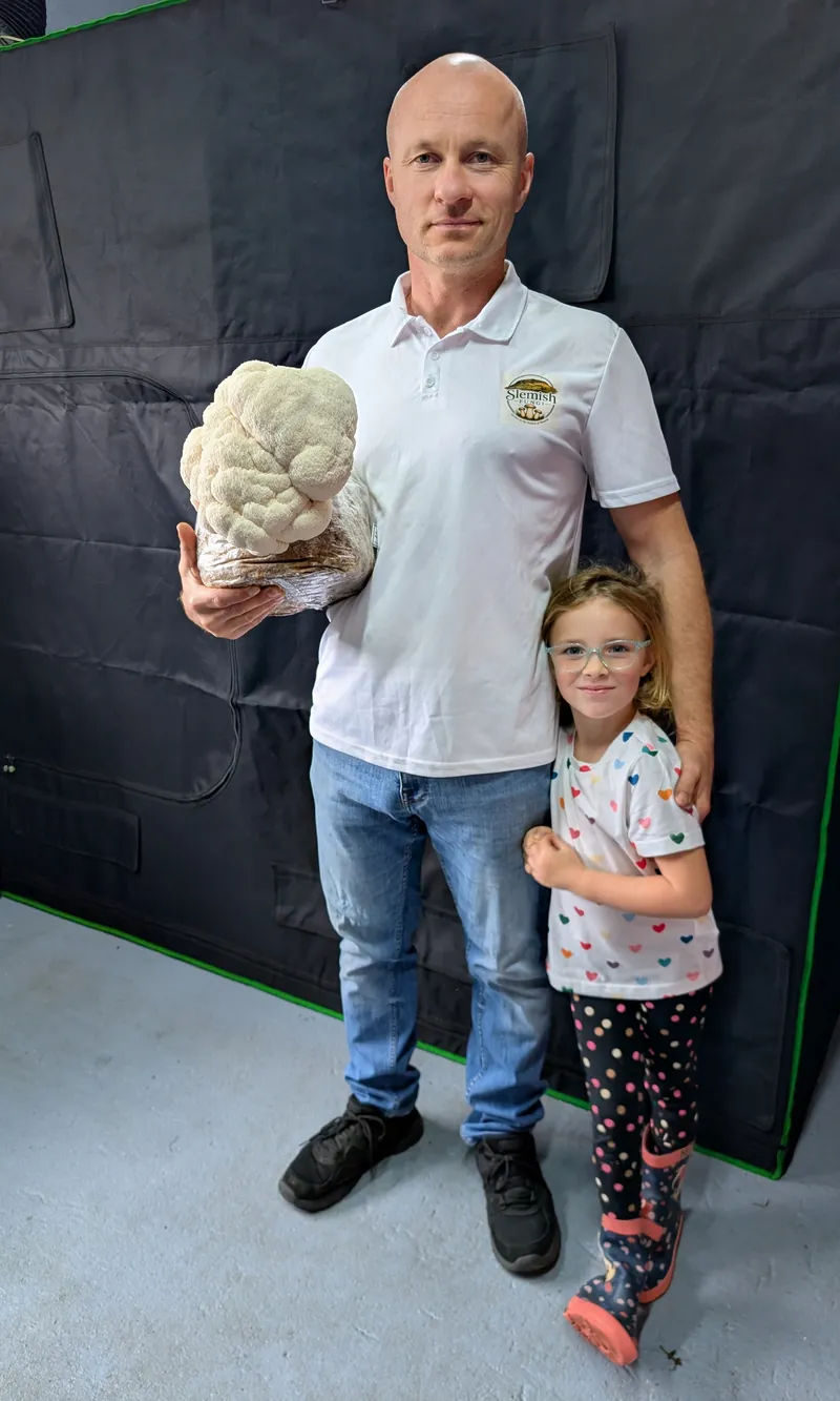 Holding a freshly grown Lion's Mane block in the fruiting room